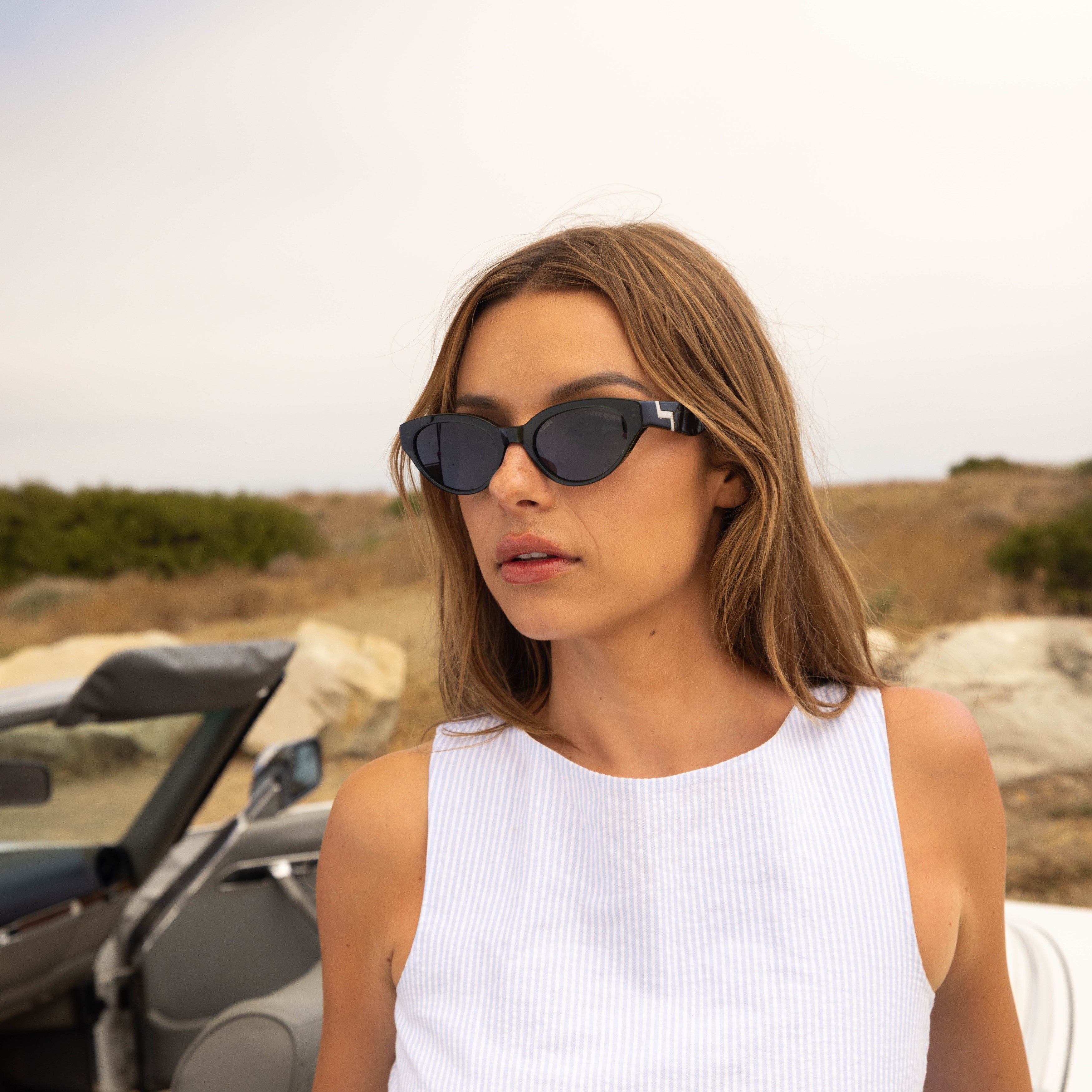 Model wearing PAIGE sunglasses in Black Crystal
